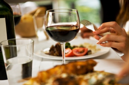 Wine on table, woman eating